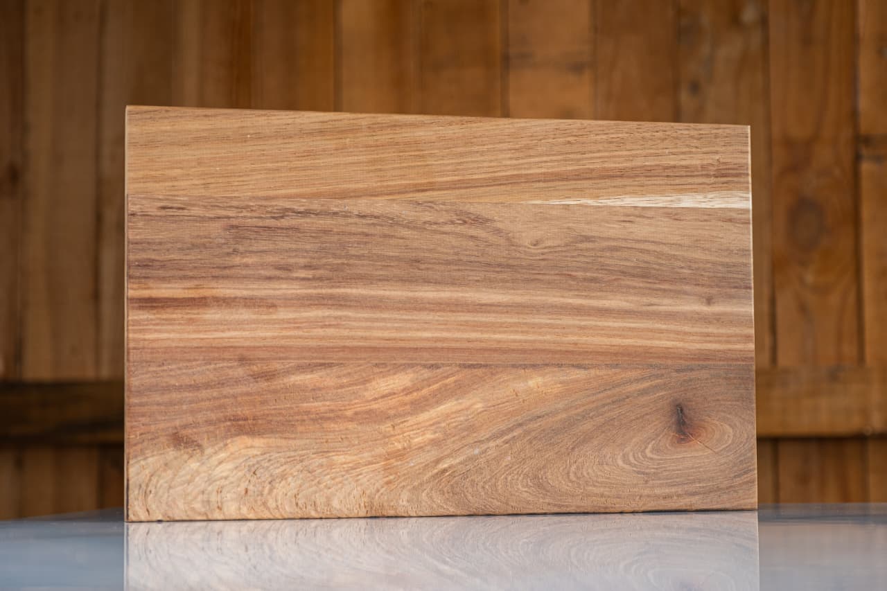 Solid Kiaat Cutting Board displayed on a marble counter